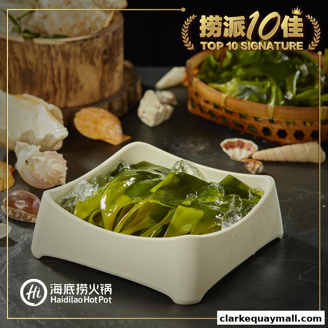 A bowl of fresh kelp served on ice, with decorative shells and a basket of greens.