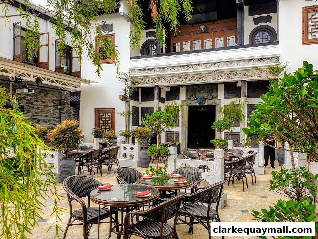 An outdoor seating area with tables and chairs in front of a traditional building.