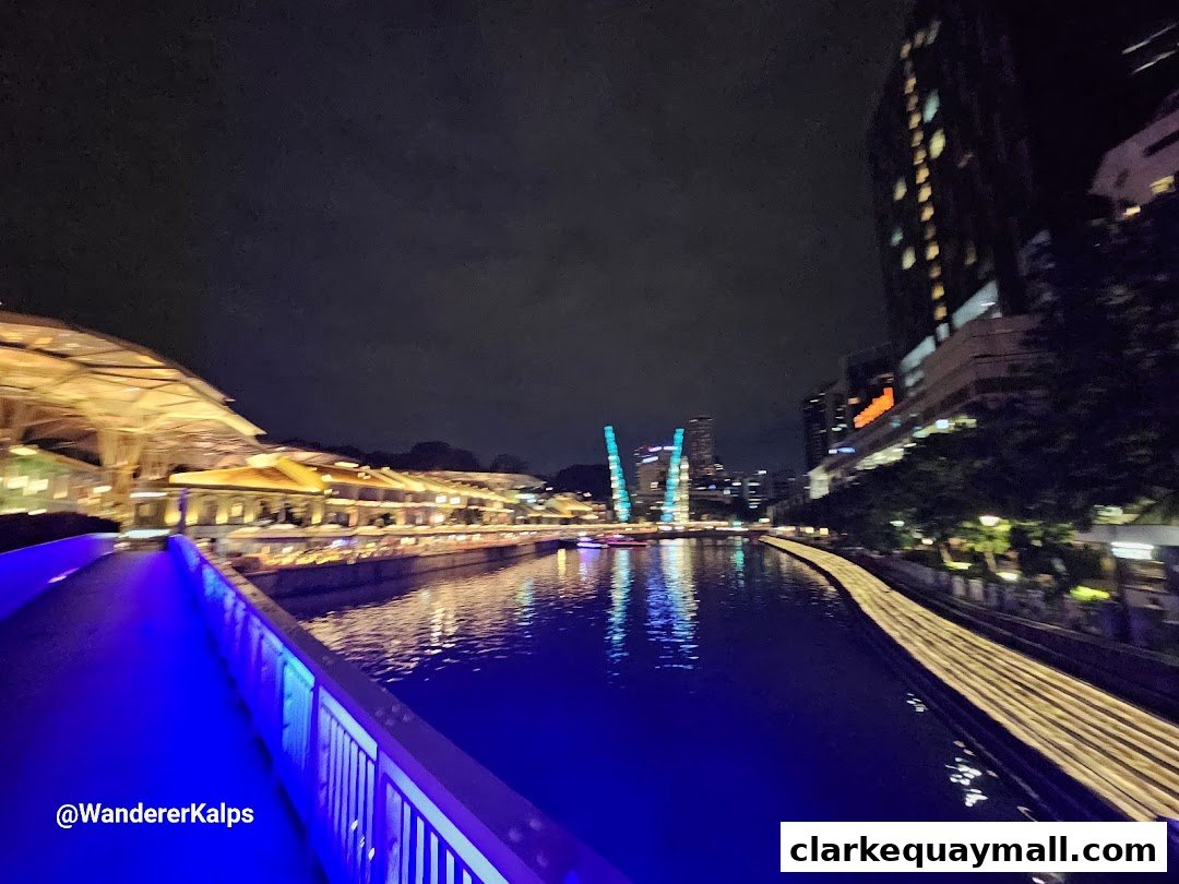 A scenic night view of a river cruise terminal with illuminated buildings and water.