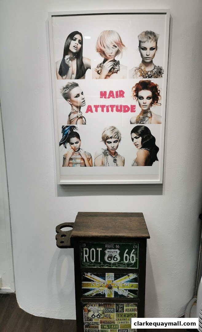 A framed collage of hairstyles and the shop name 'Hair Attitude' above a decorative cabinet.