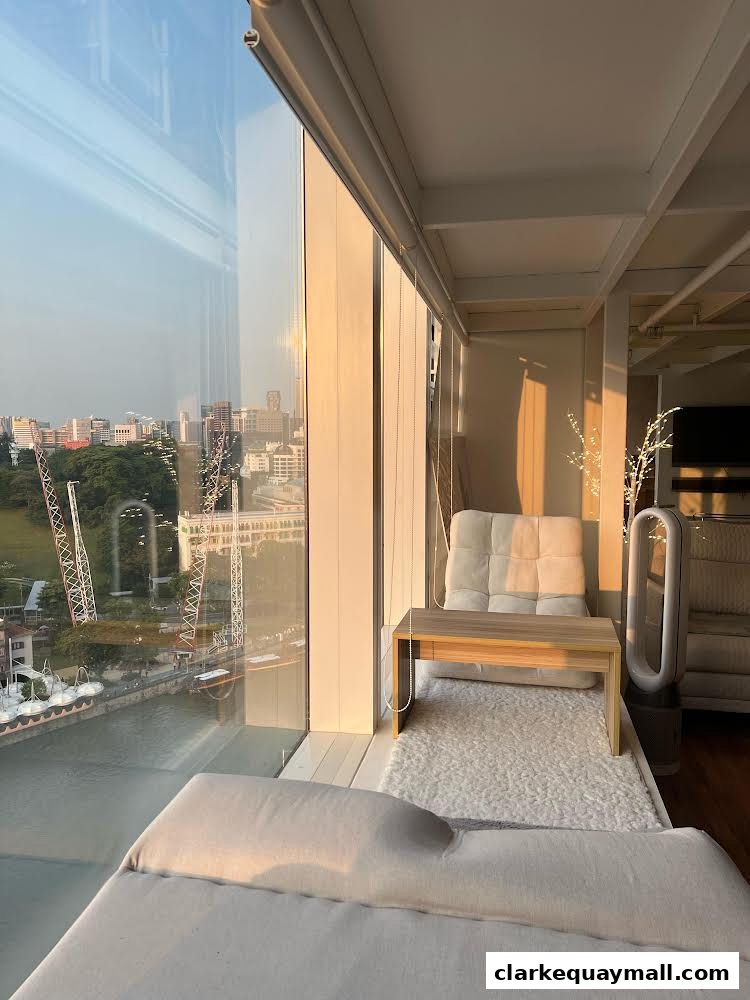 A cozy seating area with a view of the city and river at sunset.