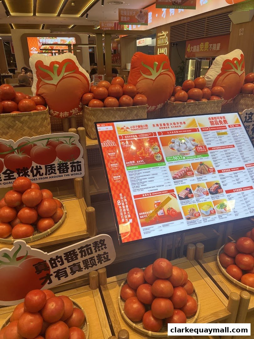 A display of fresh tomatoes and a digital menu for a tomato hot pot restaurant.