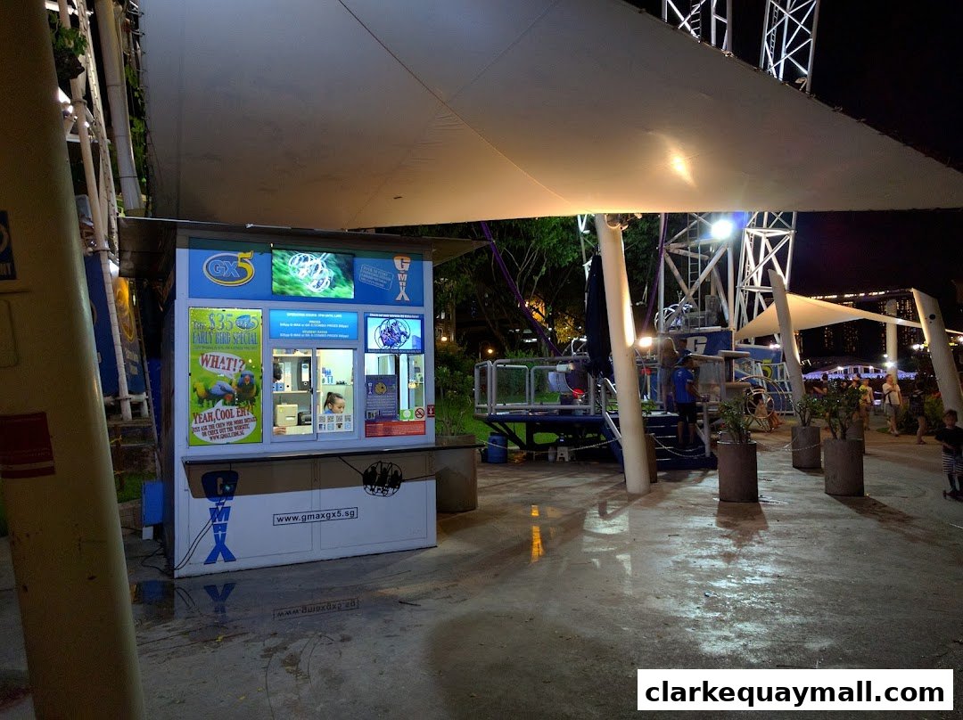 The GX-5 Extreme Swing shop front at night, with promotional displays and a ticket counter.