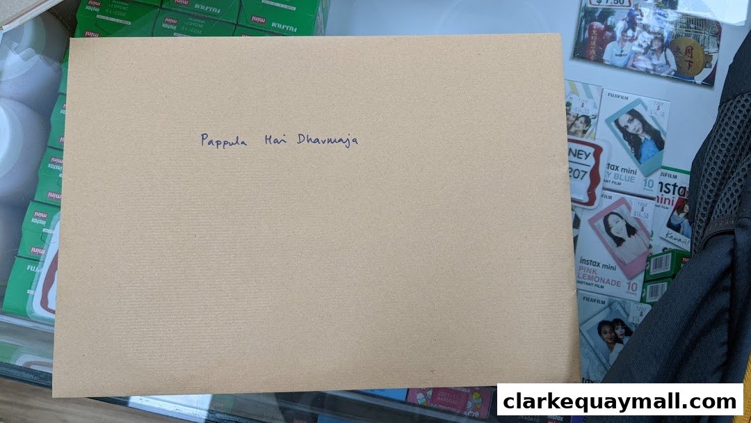 A brown envelope with handwritten text sits on a display of Fujifilm Instax film.