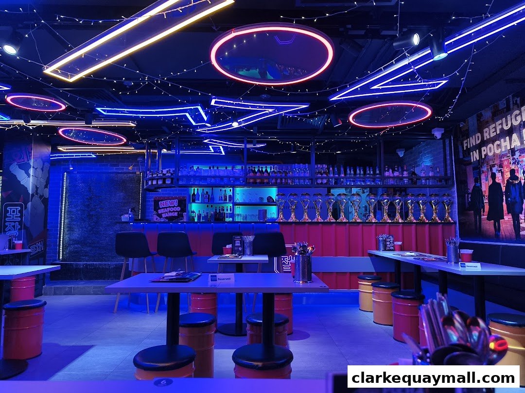 Interior of a Korean street dining restaurant with neon lights and a bar.
