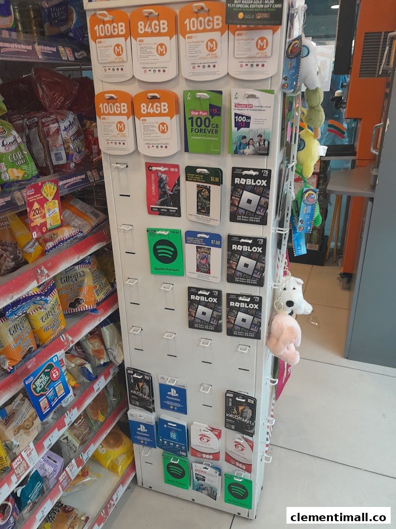 A display rack inside 7-Eleven featuring various gift cards, SIM cards, and digital vouchers next to snack shelves.
