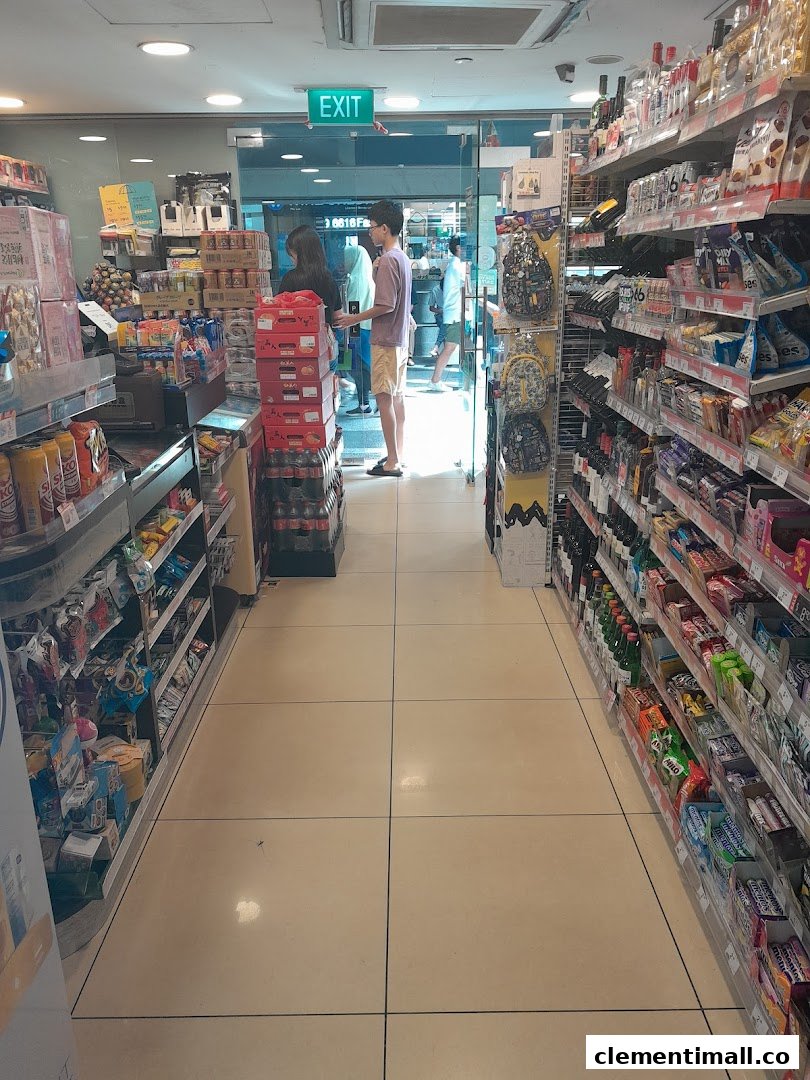 An interior view of a 7-Eleven store aisle, showcasing shelves stocked with various products and customers near the exit.