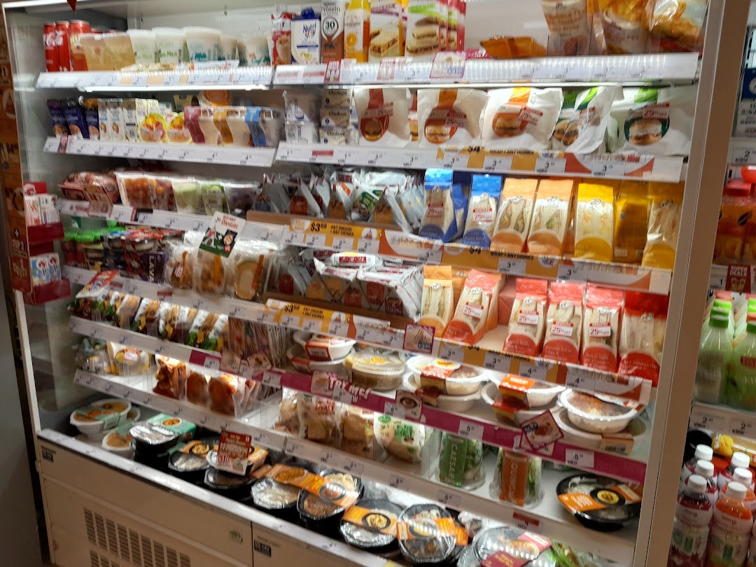 A well-stocked refrigerated display at 7-Eleven featuring ready-to-eat meals, sandwiches, and beverages.