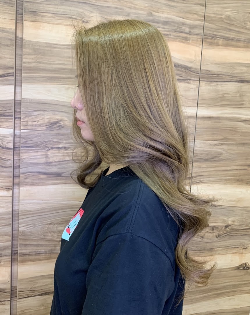 A side profile of a person showcasing beautifully styled, light brown hair with soft waves.