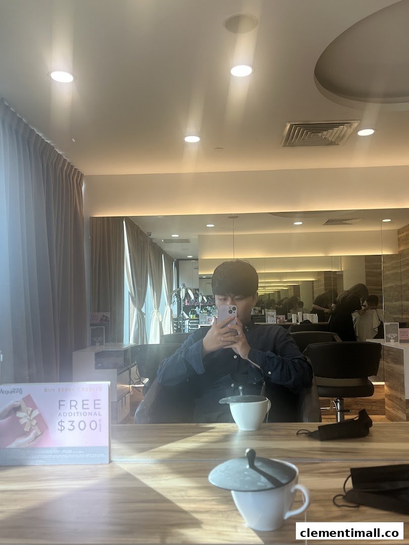 A customer sits in a modern hair studio, reflected in a mirror, with a promotional offer visible.