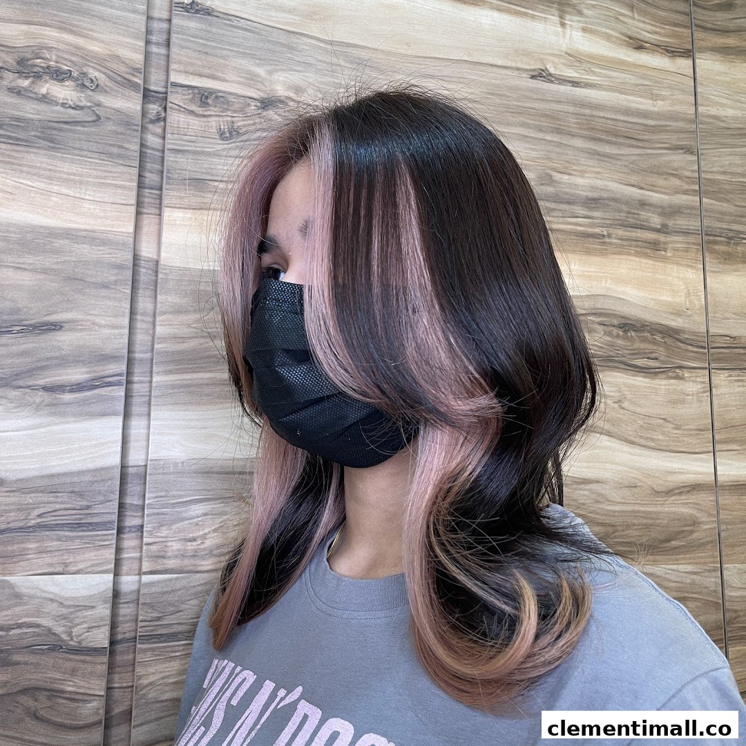 A person showcases a stylish new hair color with pink highlights and dark brown base.