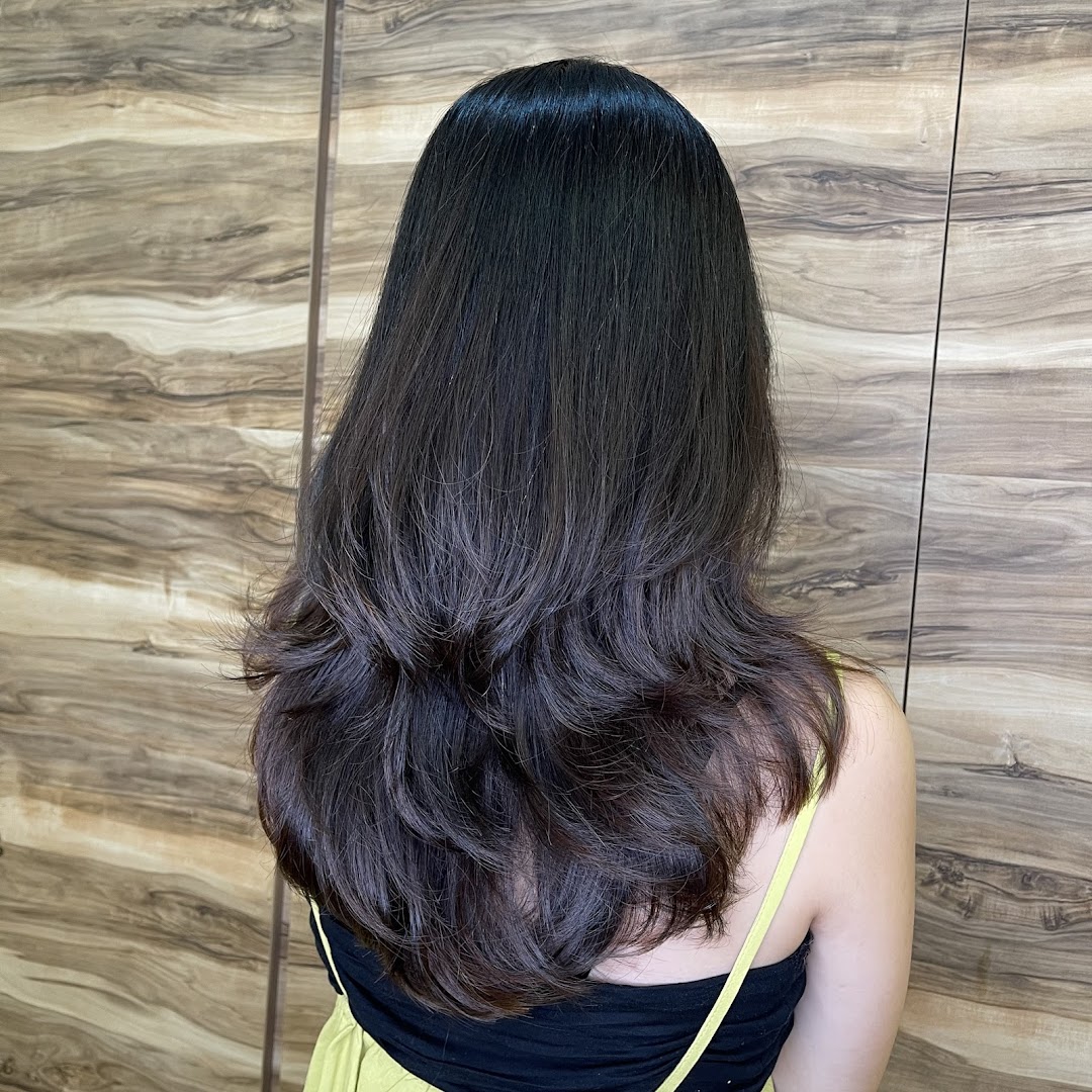 A person's back showcasing beautifully styled long, layered dark hair with waves.