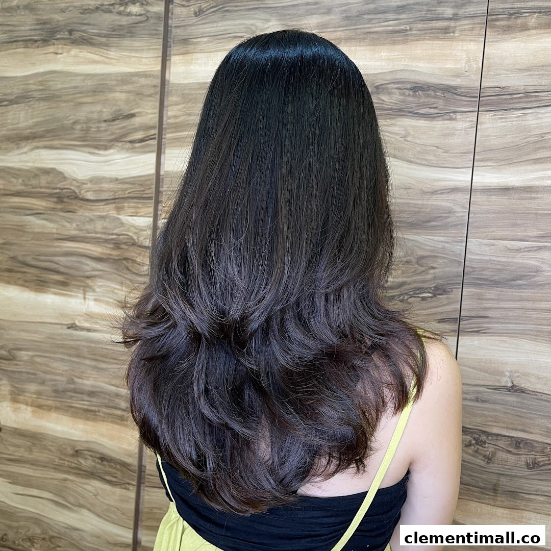 A person's back showcasing beautifully styled long, layered dark hair with waves.