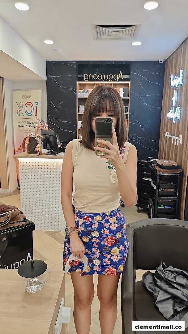A person taking a mirror selfie inside Apgujeong Hair Studio, showcasing the salon's modern interior.