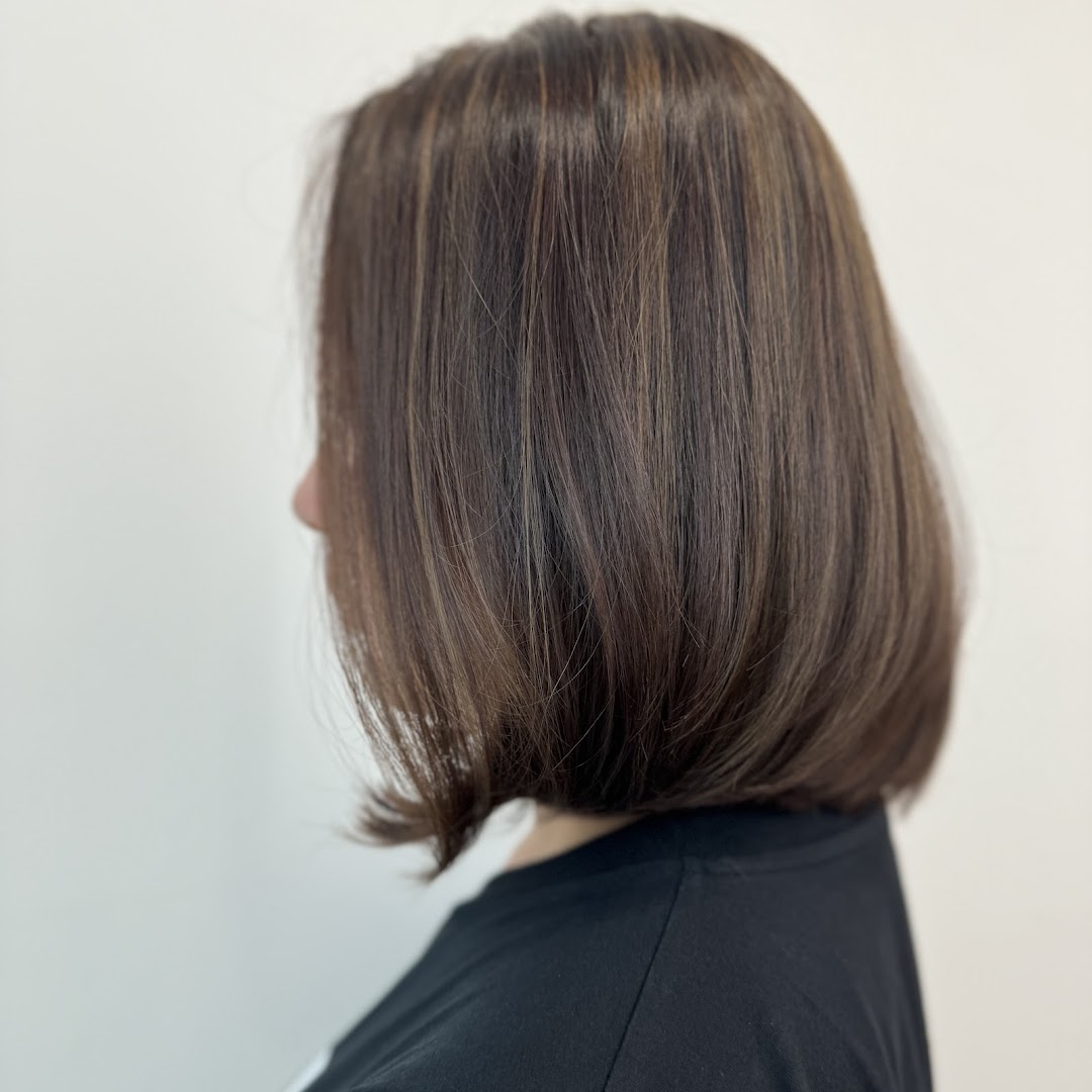 A side profile of a person showcasing a chic bob haircut with subtle highlights.
