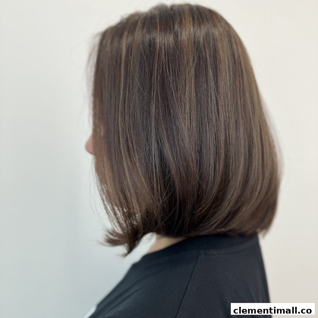 A side profile of a person showcasing a chic bob haircut with subtle highlights.