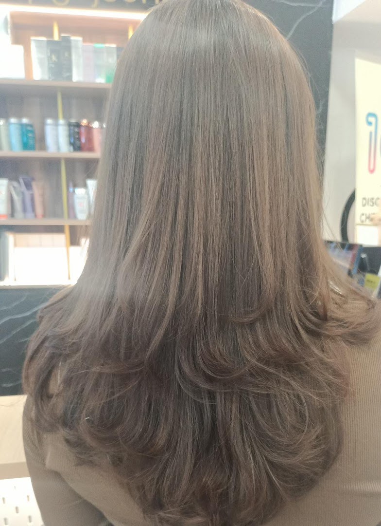 Back view of a person with freshly styled, layered hair, showcasing salon services.
