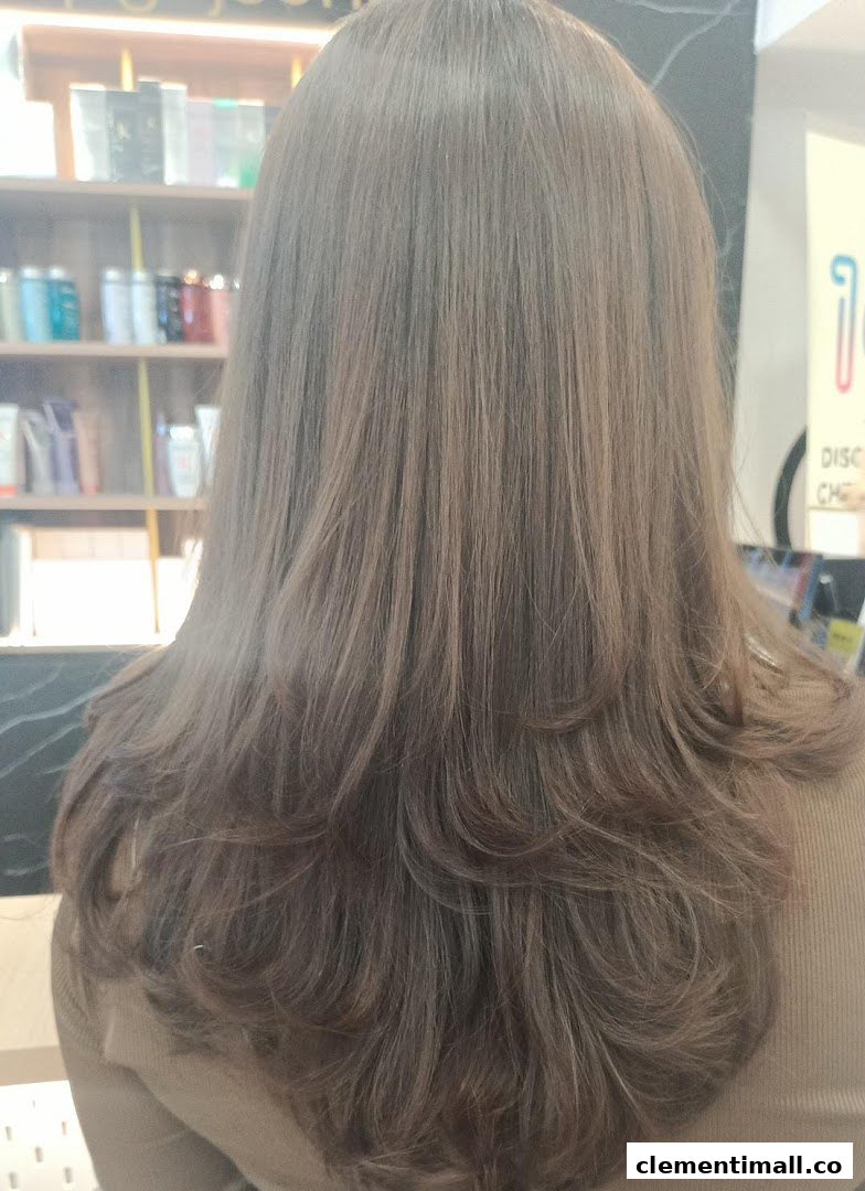 Back view of a person with freshly styled, layered hair, showcasing salon services.