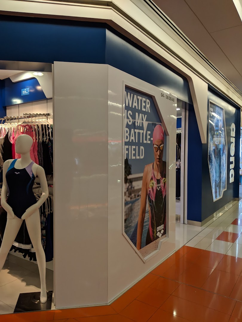 The vibrant blue and white shopfront of Arena, showcasing swimwear on mannequins and a 'Water is my Battlefield' poster.