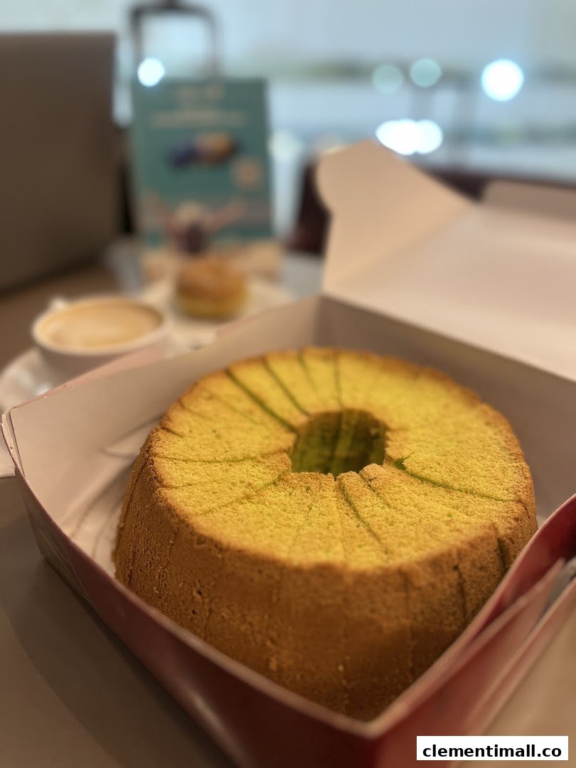 A delicious pandan chiffon cake in a box, accompanied by a cup of coffee.