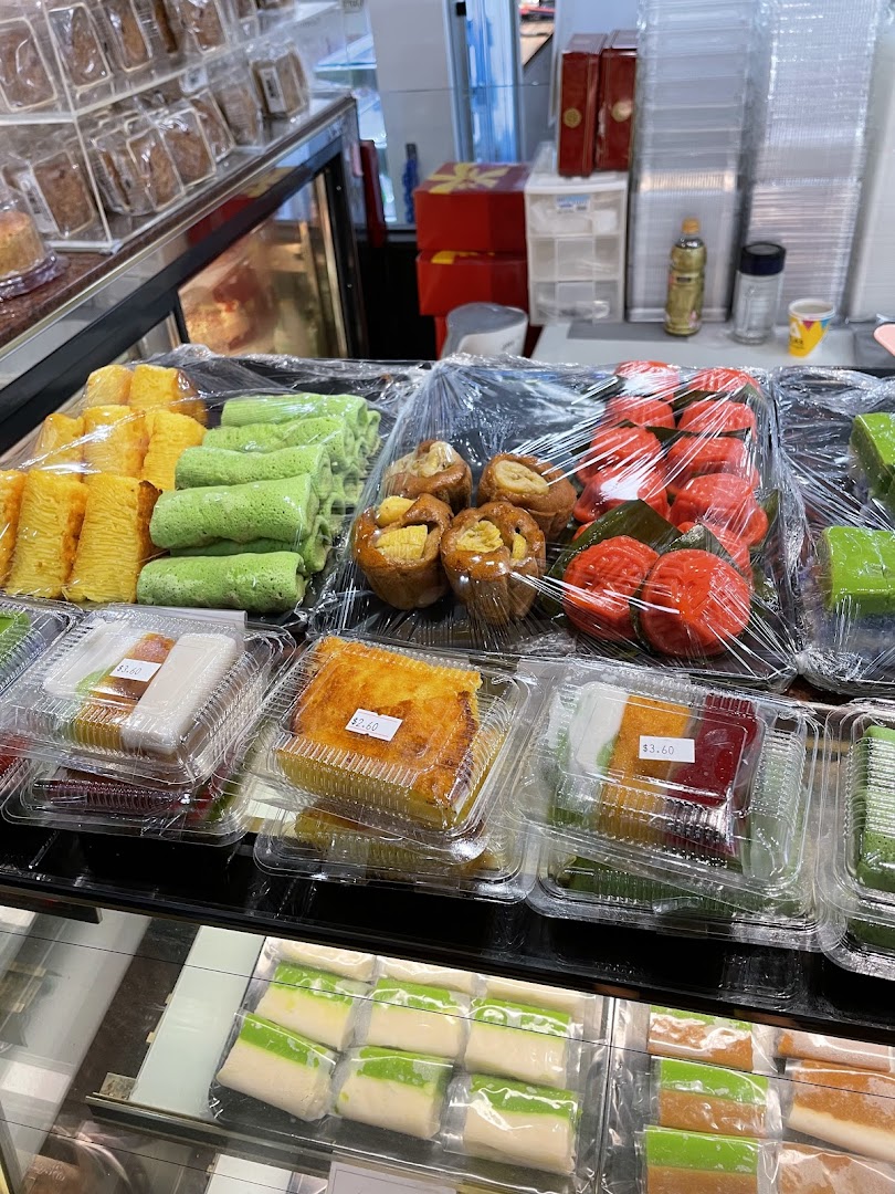 A vibrant display of traditional Indonesian cakes and snacks, including colorful kue and pastries, ready for purchase.