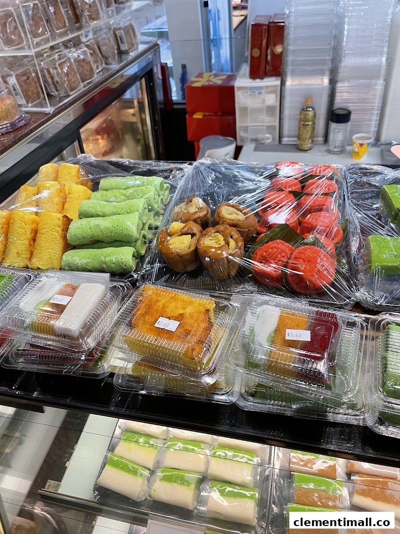 A vibrant display of traditional Indonesian cakes and snacks, including colorful kue and pastries, ready for purchase.