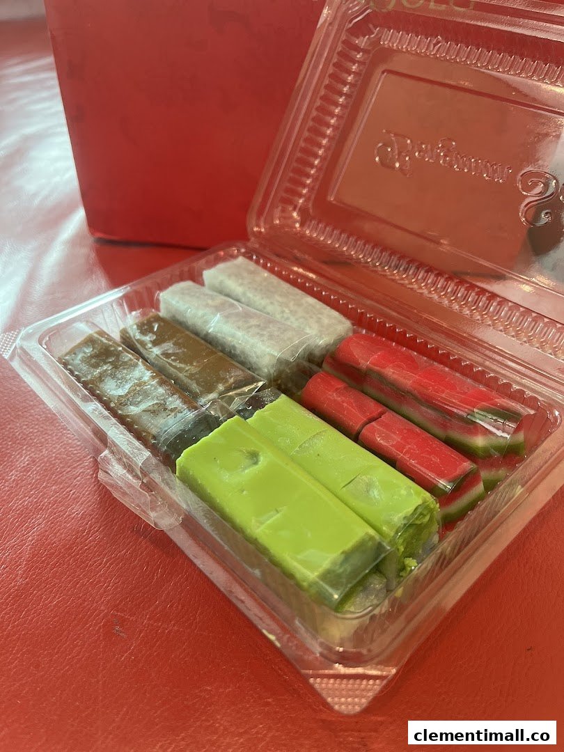 A clear plastic container holds an assortment of colorful traditional Indonesian sweets from Bengawan Solo.