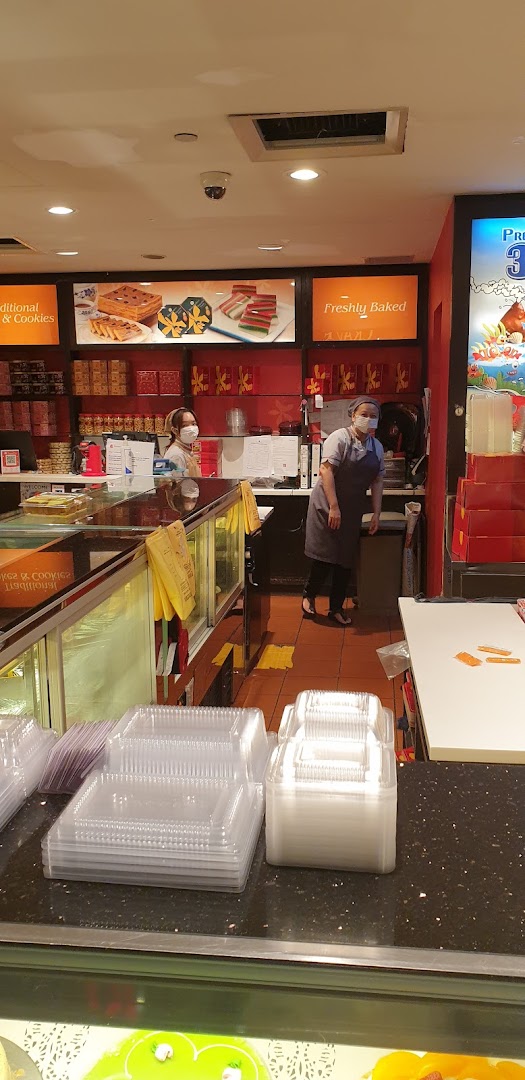 Interior view of Bengawan Solo bakery with staff, display cases, and packaging supplies.