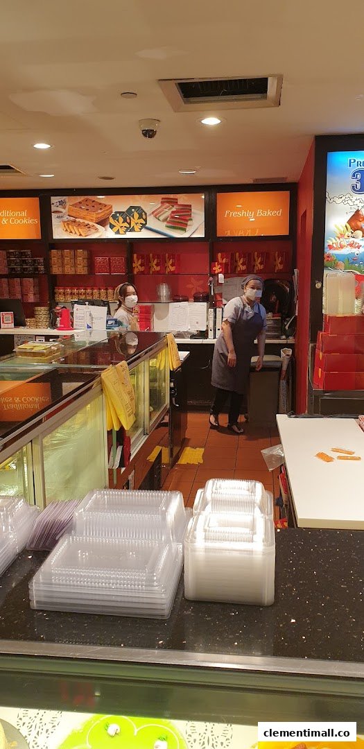 Interior view of Bengawan Solo bakery with staff, display cases, and packaging supplies.