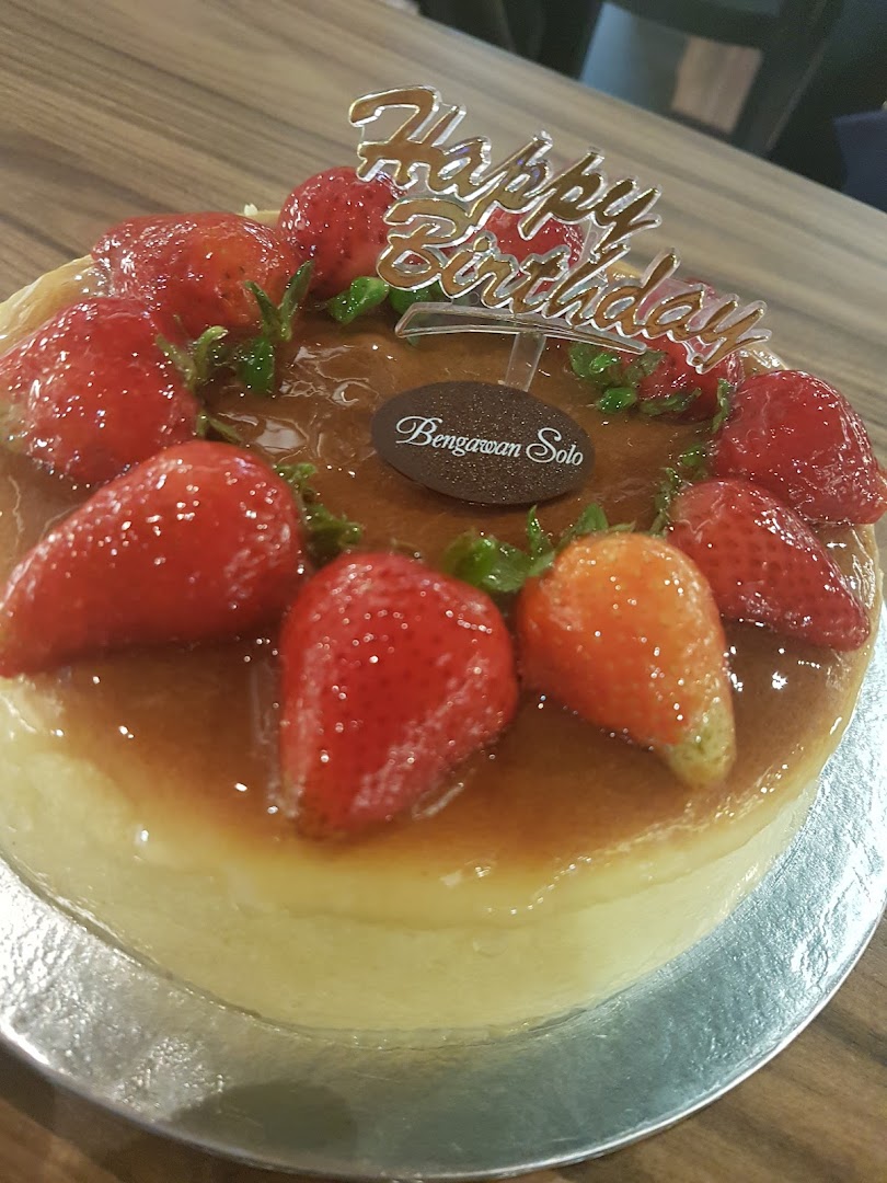 A delicious strawberry-topped cake with a 'Happy Birthday' topper from Bengawan Solo.
