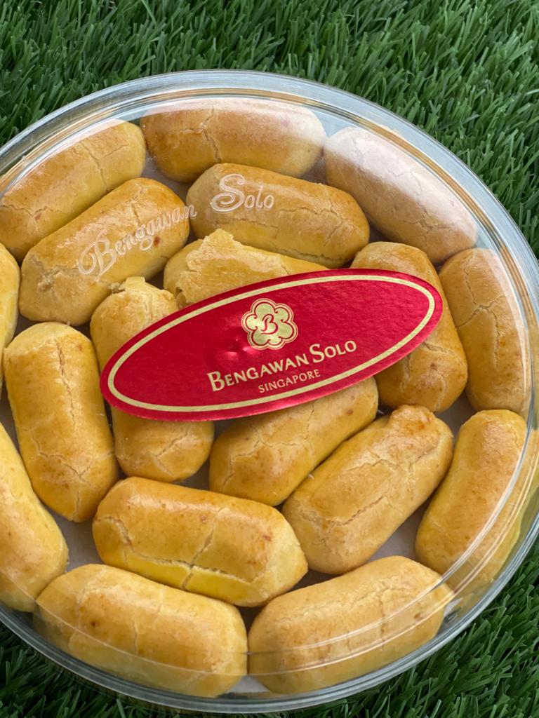 A clear container filled with golden-brown pastries, featuring the 'Bengawan Solo Singapore' brand label.