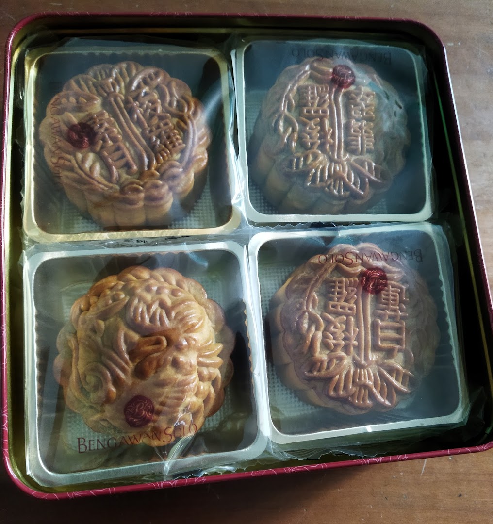 A tin box containing four intricately designed mooncakes, individually wrapped, from Bengawan Solo.