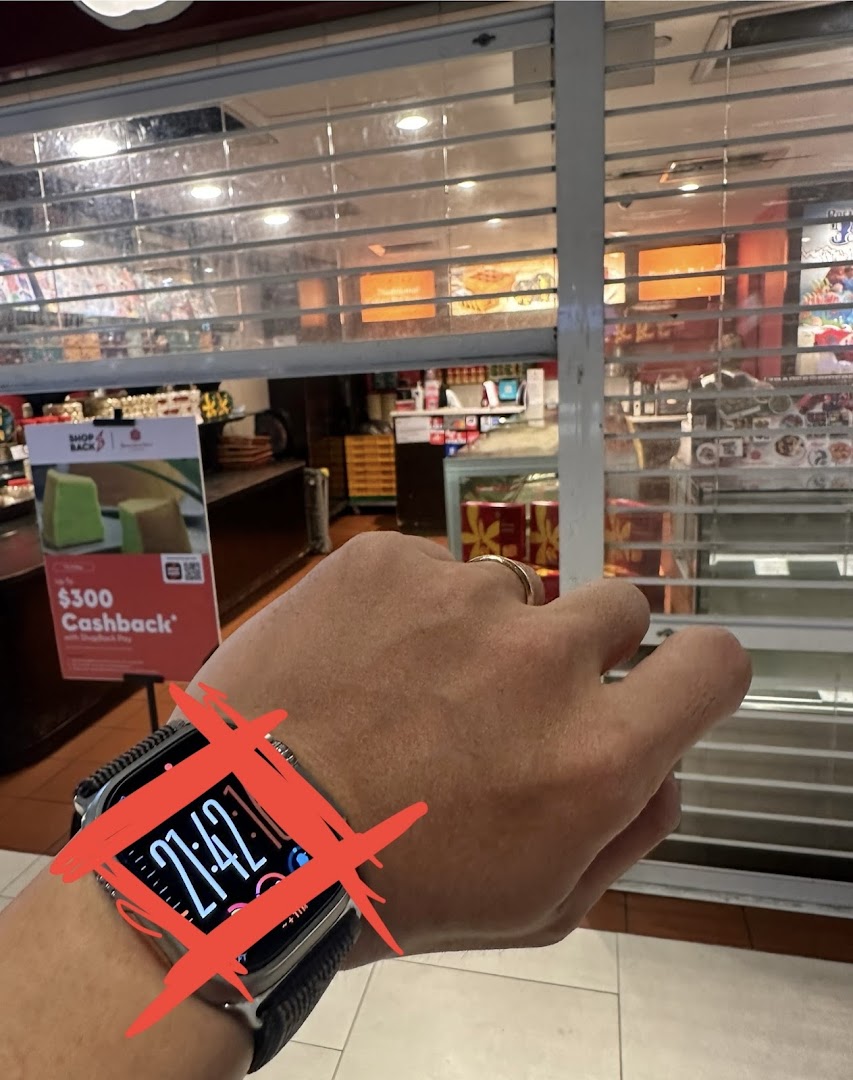 View of Bengawan Solo shop interior through a partially closed security shutter, showing products and a promotional sign.