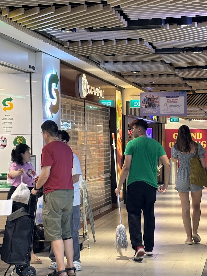 The closed shop front of Bengawan Solo in a mall, with people and a cleaner passing by.