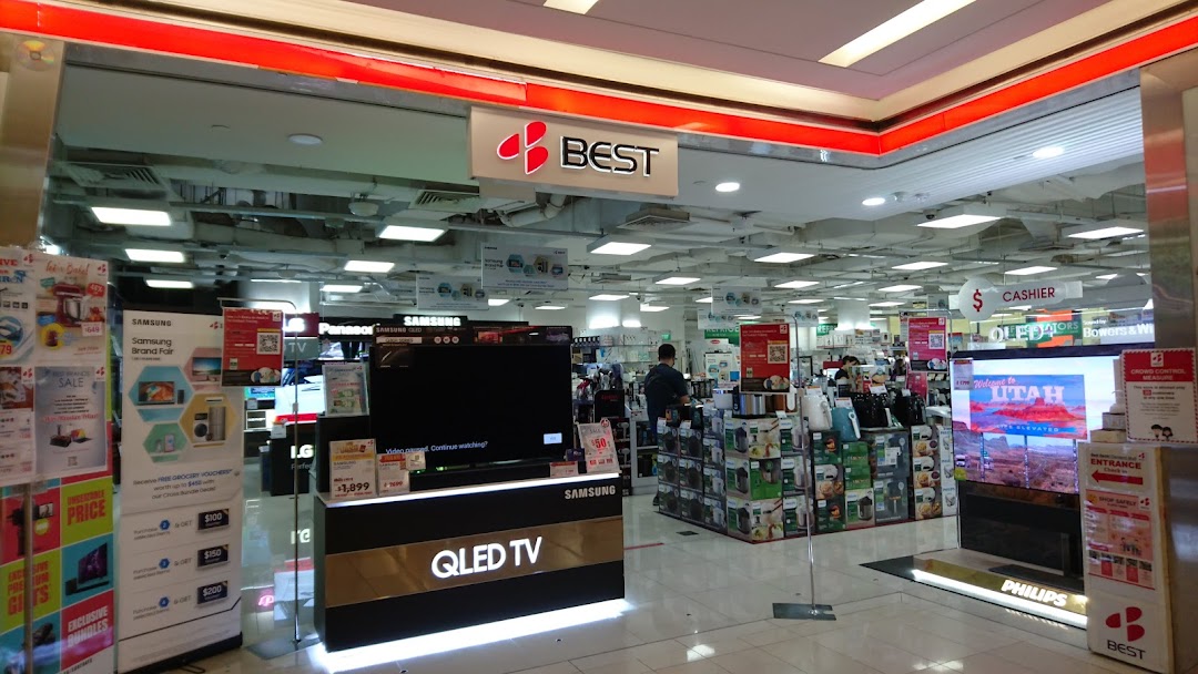 The entrance of Best Denki electronics store, showcasing various TVs and home appliances.