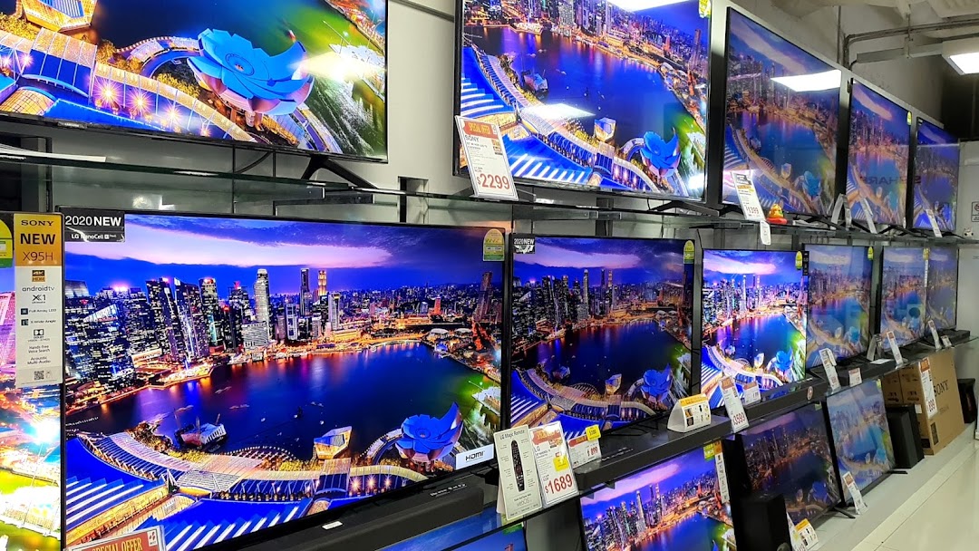 A wide array of televisions displaying vibrant cityscapes are showcased in an electronics store.