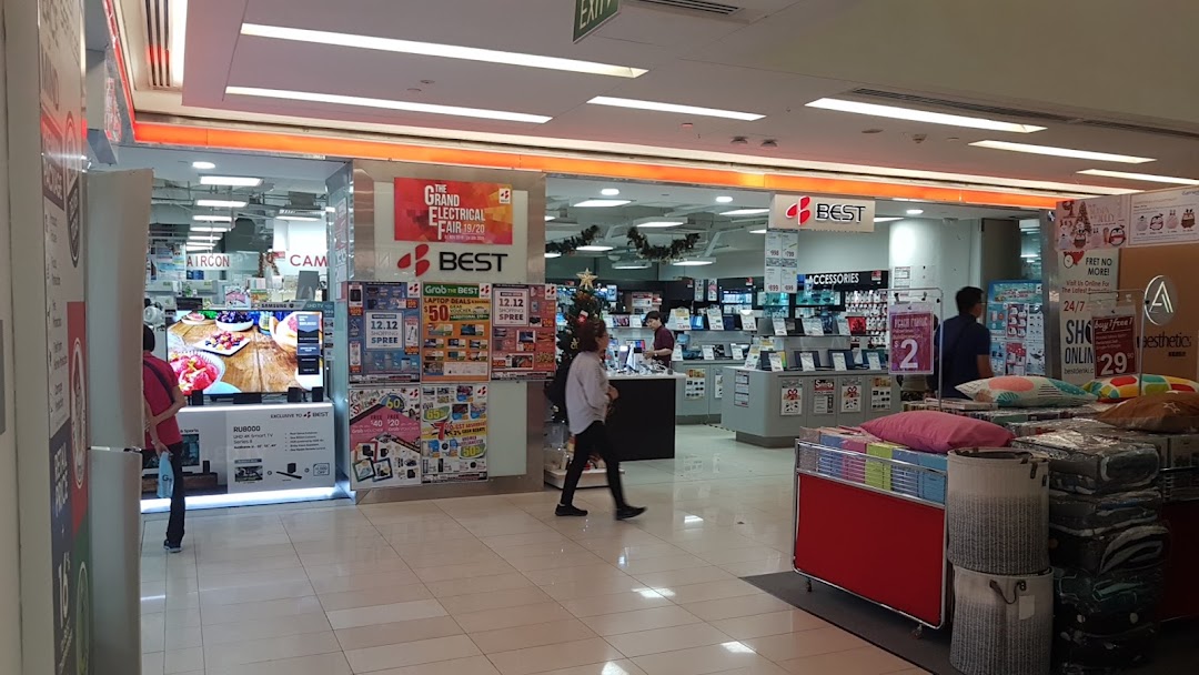 An electronics store interior showcasing various appliances, laptops, and accessories, with customers browsing.