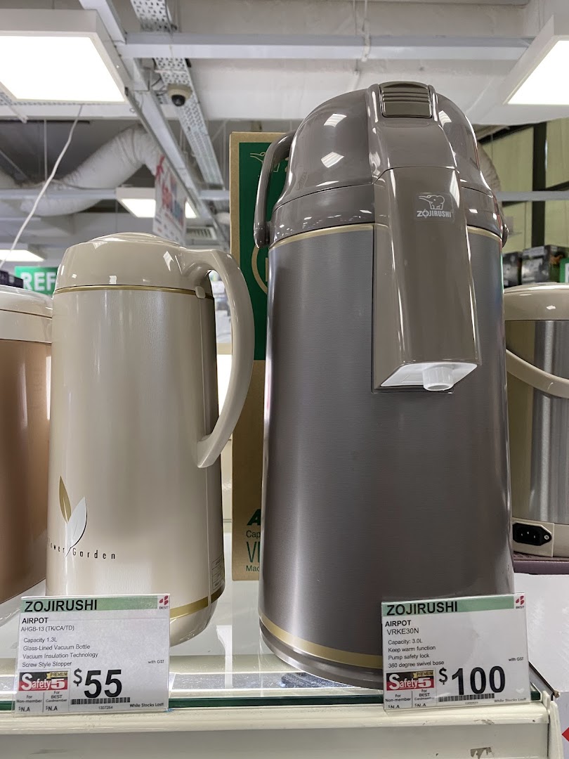 Two Zojirushi airpots displayed with their features and prices on a shelf in an electronics store.