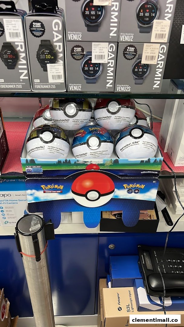 A retail display featuring Garmin smartwatches and Pokémon Trading Card Game Poke Ball products inside an electronics store.