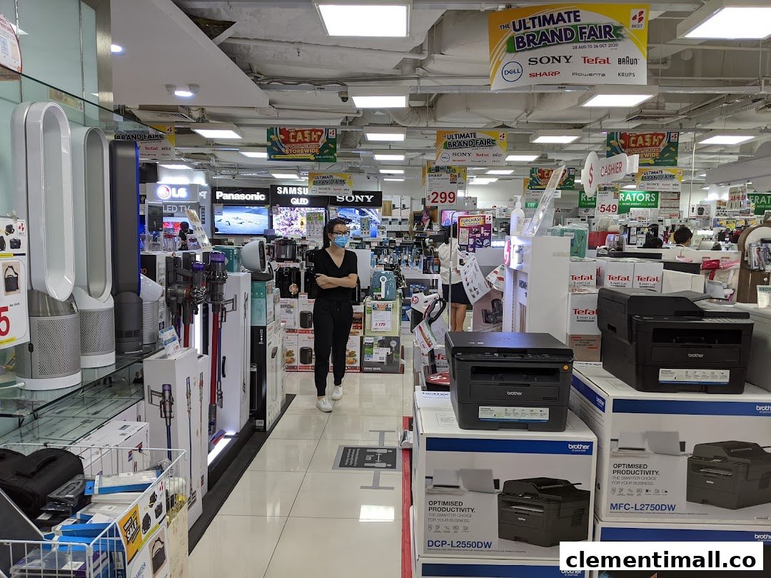 Interior view of Best Denki, an electronics store, showcasing various home appliances and a customer browsing.