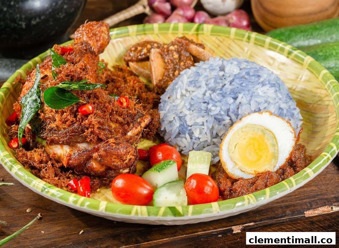 A vibrant plate of Nasi Lemak featuring crispy fried chicken, blue pea rice, and a fried egg.