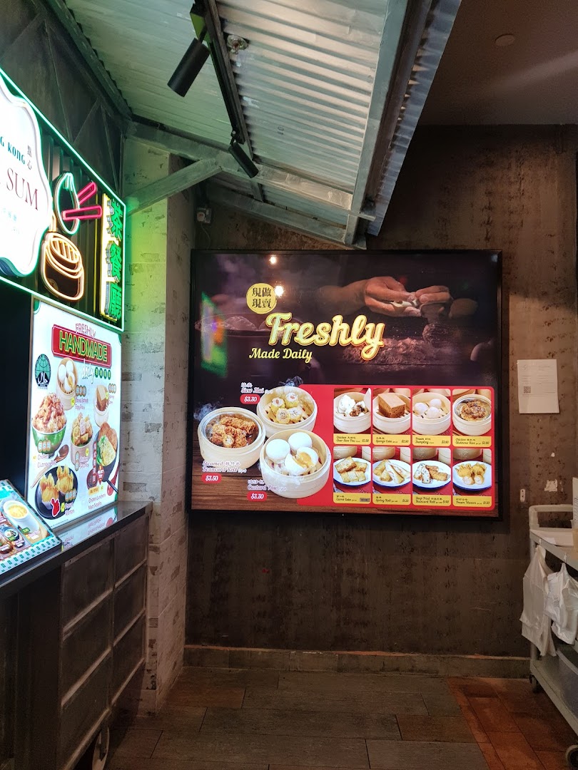 A digital menu board displaying various freshly made dim sum items with prices inside a shop.