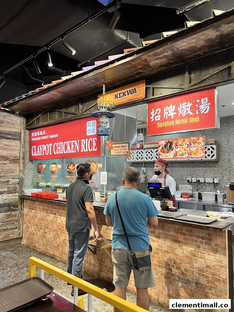 Customers ordering Claypot Chicken Rice and Signature Herbal Soup at a food stall counter.