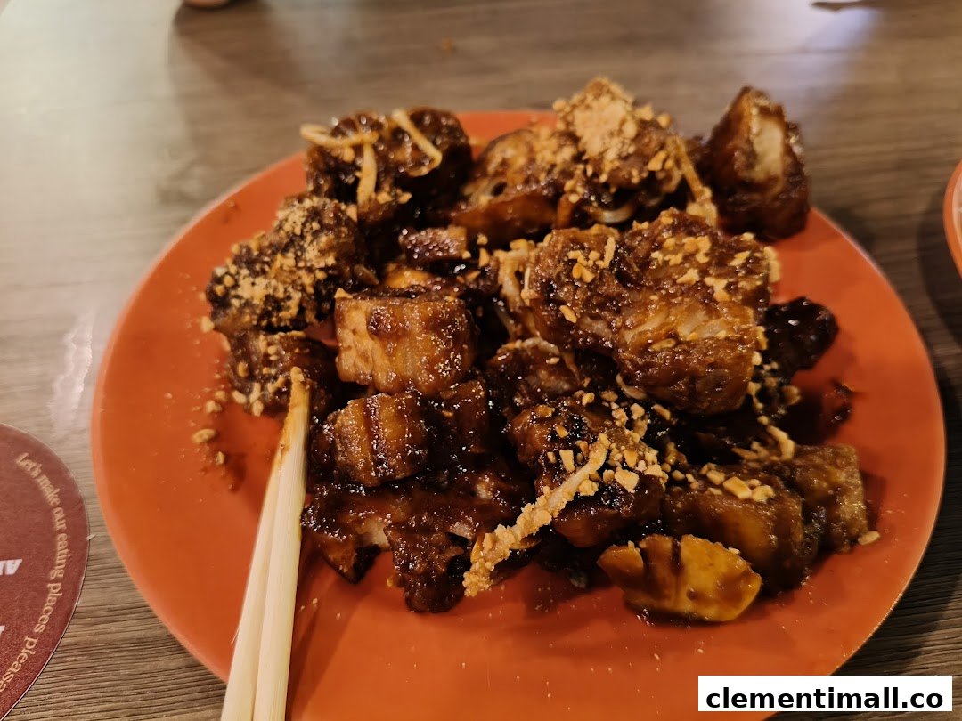 A close-up of a delicious plate of Rojak with dark sauce and crushed peanuts, served with chopsticks.