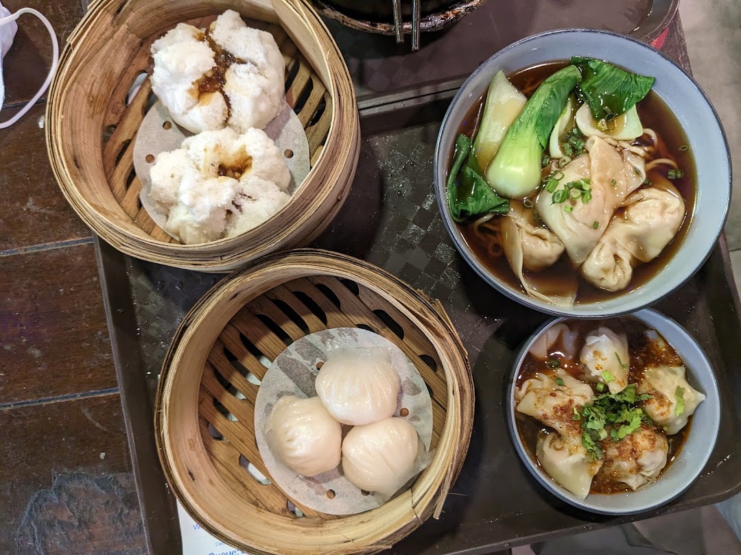 A delicious spread of dim sum, wanton noodles, and chili oil wontons served on a tray.