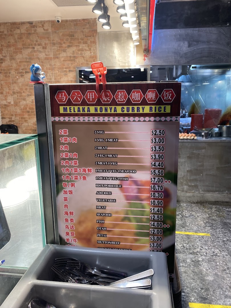 A menu board displaying prices and options for Melaka Nonya Curry Rice.