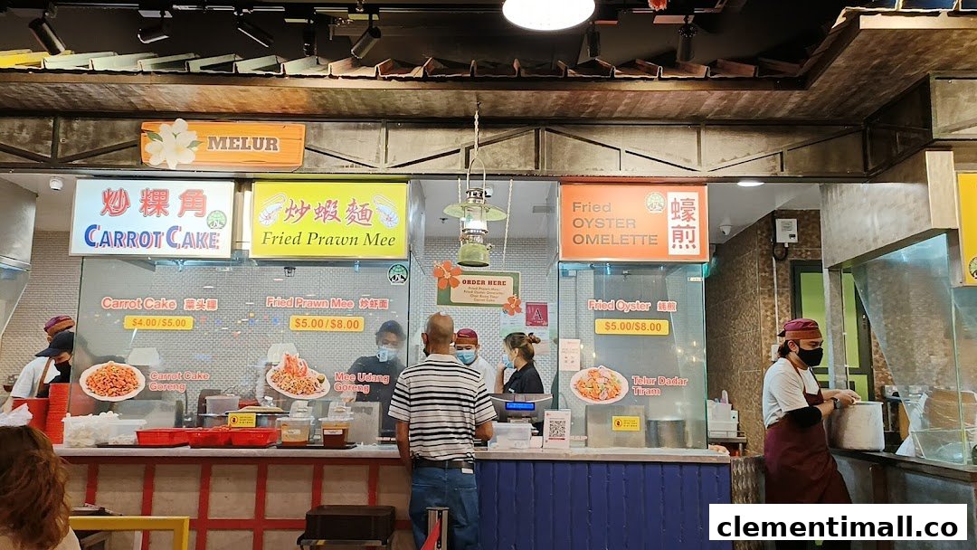 A bustling food stall counter at Melur, serving local dishes like Carrot Cake and Fried Prawn Mee.