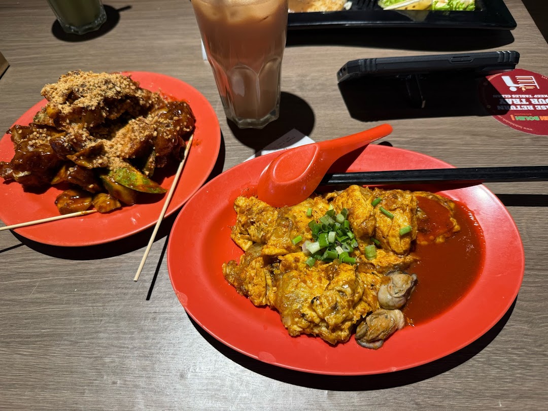 Two plates of delicious local dishes, Rojak and Oyster Omelette, with drinks on a table.