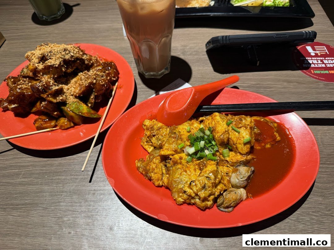 Two plates of delicious local dishes, Rojak and Oyster Omelette, with drinks on a table.