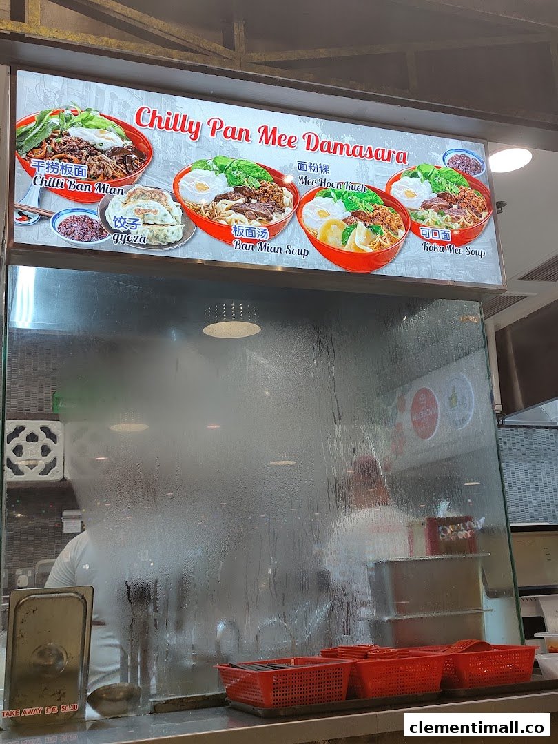 A vibrant menu board for 'Chilly Pan Mee Damasara' showcasing various noodle dishes and gyoza above a food stall counter.